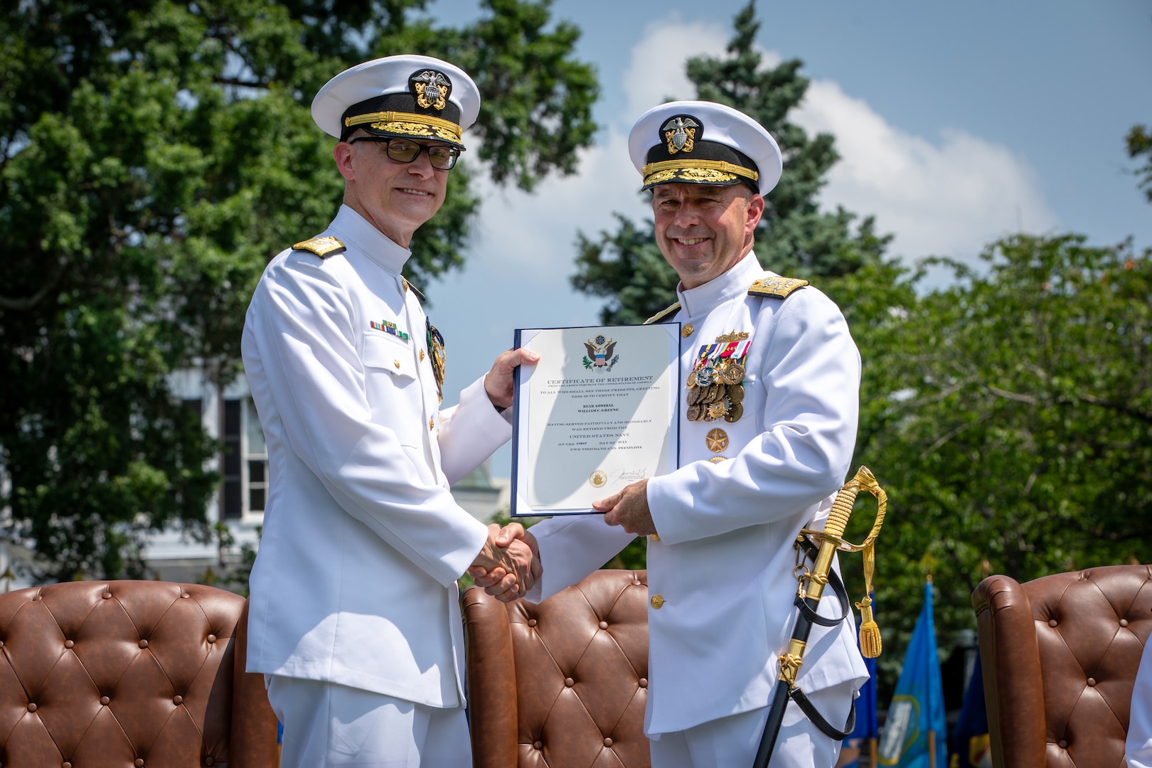 Admiral Jim Kilby, acting Chief of Naval Operations (right) presents Rear Adm. William Greene with a certificate of retirement during a retirement and change of office ceremony held at the Washington Navy Yard’s Leutze Park, June 6. Rear Admiral Andrew Biehn relieved Greene as Director of Surface Ship Maintenance, Modernization, and Sustainment (SEA 21). (U.S. Navy photo by Laura Lakeway)