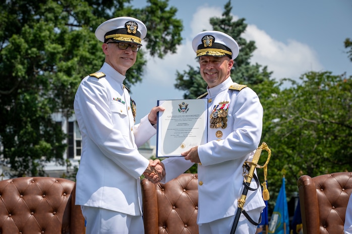 Admiral Jim Kilby, acting Chief of Naval Operations (right) presents Rear Adm. William Greene with a certificate of retirement during a retirement and change of office ceremony held at the Washington Navy Yard’s Leutze Park, June 6. Rear Admiral Andrew Biehn relieved Greene as Director of Surface Ship Maintenance, Modernization, and Sustainment (SEA 21). (U.S. Navy photo by Laura Lakeway)