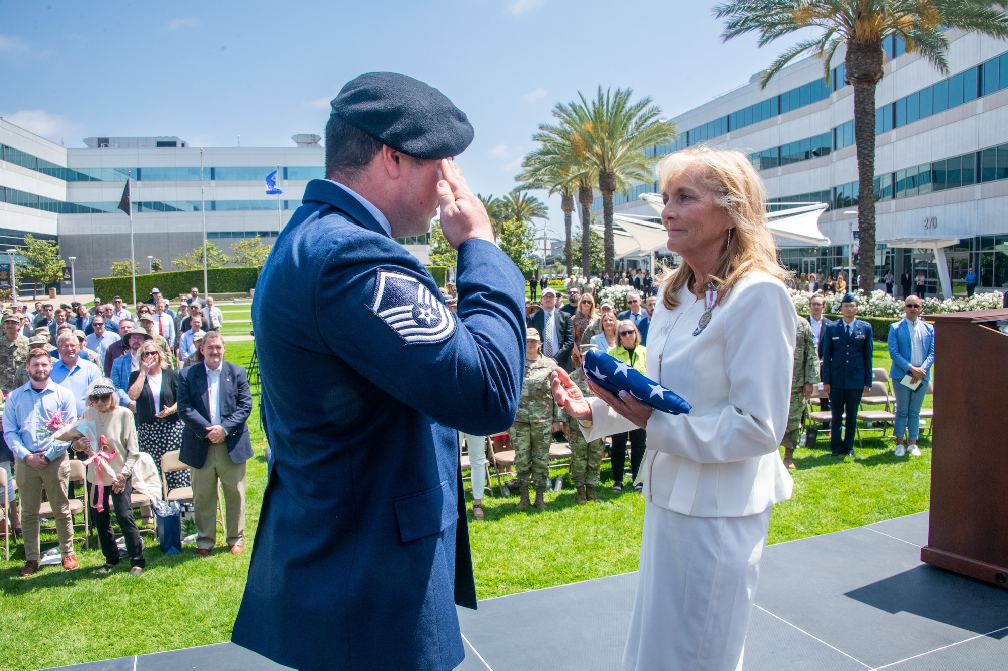 Ms. Joy White, executive director of Space Systems Command and a member of Senior Executive Service, receives a folded American flag from a member of the color guard at the conclusion of her retirement ceremony May 29, 2025, at Los Angeles Air Force Base. As a symbolic gesture of gratitude from the command, the flag flying over the headquarters of Space Systems Command was retired and presented to Ms. White.
