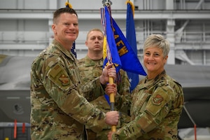 U.S. Air Force Col. Paul Townsend, left, 354th Fighter Wing commander, passes the guidon to Col. Michele Suggs, 354th Medical Group incoming commander, during a change of command ceremony at Eielson Air Force Base, Alaska, June 6, 2025.