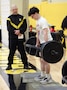 A U.S. Army recruiter looks on as a student performs the deadlift event during the U.S. Army Fitness Challenge at Shawnee Mission West High School in May 2025. The challenge provided an opportunity for students to test their strength and learn about Army fitness standards.