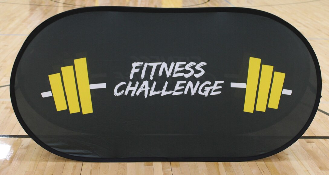 A “Fitness Challenge” banner stands at center court during a U.S. Army Fitness Challenge event at a Kansas City-area high school, May 2025. The challenge promotes physical fitness, teamwork, and Army values among high school students.