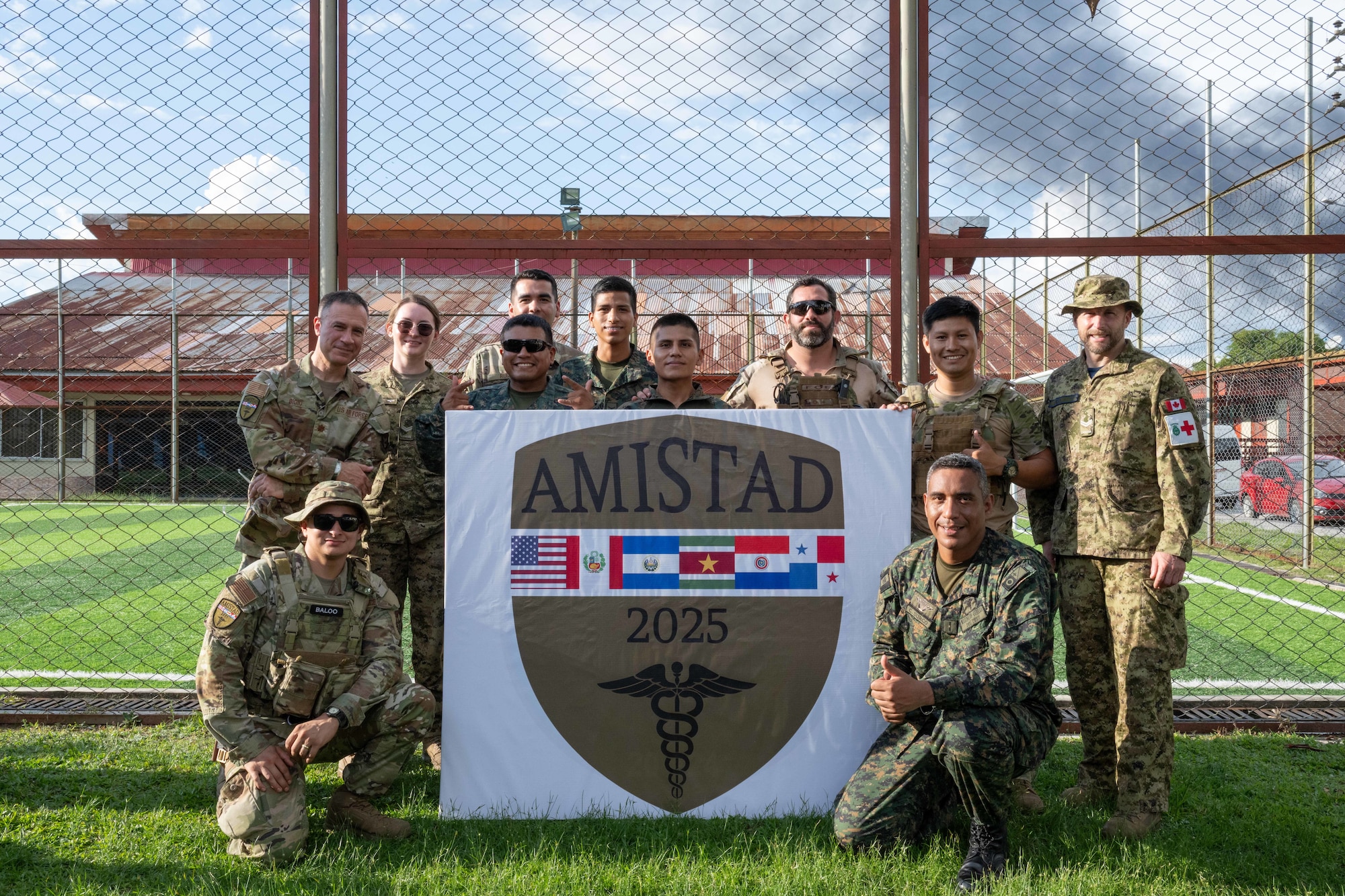 Members of the Peruvian armed forces, U.S. Air Force, and Royal Canadian Air Force pose for a photo in front of the AMISTAD 2025 emblem in Iquitos, Peru, June 4, 2025. AMISTAD exemplifies the enduring commitment of the U.S., Canada, and Peru to strengthening regional security and medical readiness through collaborative service, care, and partnership. (U.S. Air Force photo by Senior Airman Victoria Edwards)