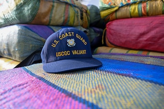 A Coast Guard hat sits on bales of drugs