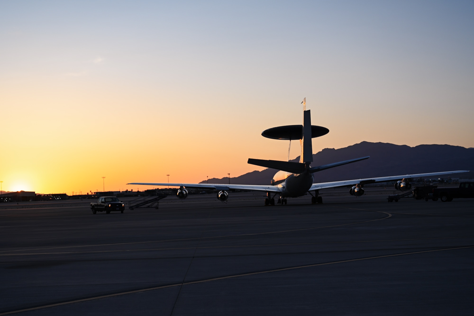 A U.S. Air Force E-3 Sentry aircraft assigned to the 552nd Air Control Wing, is parked on the flightline during sunset at Nellis Air Force Base, Nevada, May 28, 2025. The E-3 Sentry is an airborne warning and control system aircraft that provides command and control, surveillance, and tracking to help detect and manage targets during operations. (U.S. Air Force photo by Airman 1st Class Jonah Bliss)