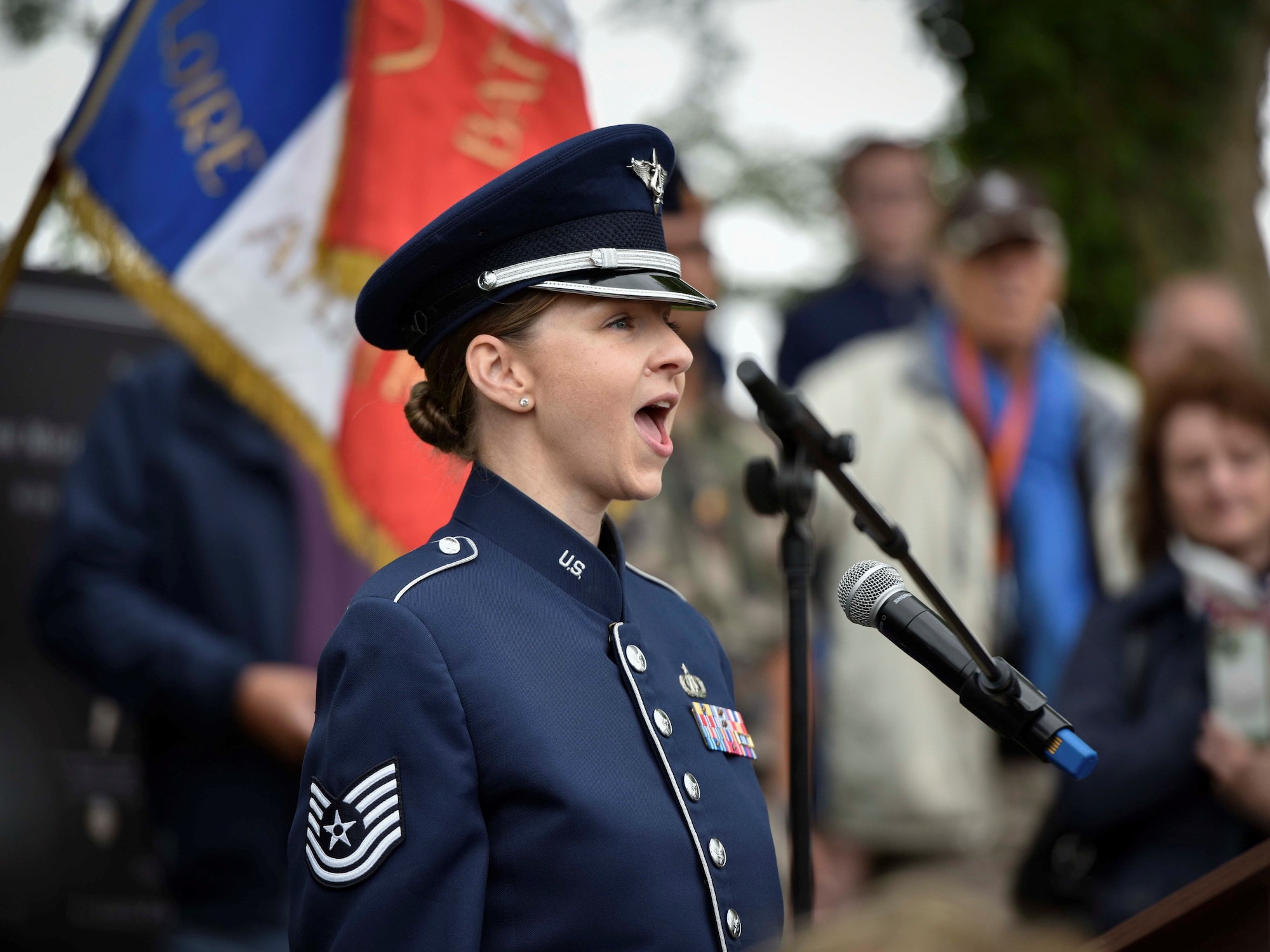 U.S. Air Force Tech Sgt. Michelle Doolittle assigned to U.S. Air Forces in Europe Band sings the U.S. and French national anthems during a ceremony commemorating D-Day and the unveiling of the 8th Air Force memorial at Sainte-Mère-Église, Normandy, France, June 5, 2025. As the great grandniece of the former 8th Air Force Commander, Gen. James “Jimmy” Doolittle, Tech Sgt. Doolittle carries on her family’s legacy as a vocalist, using music to strengthen U.S. Air Force international ties and commemorate shared history with Allies and partners.