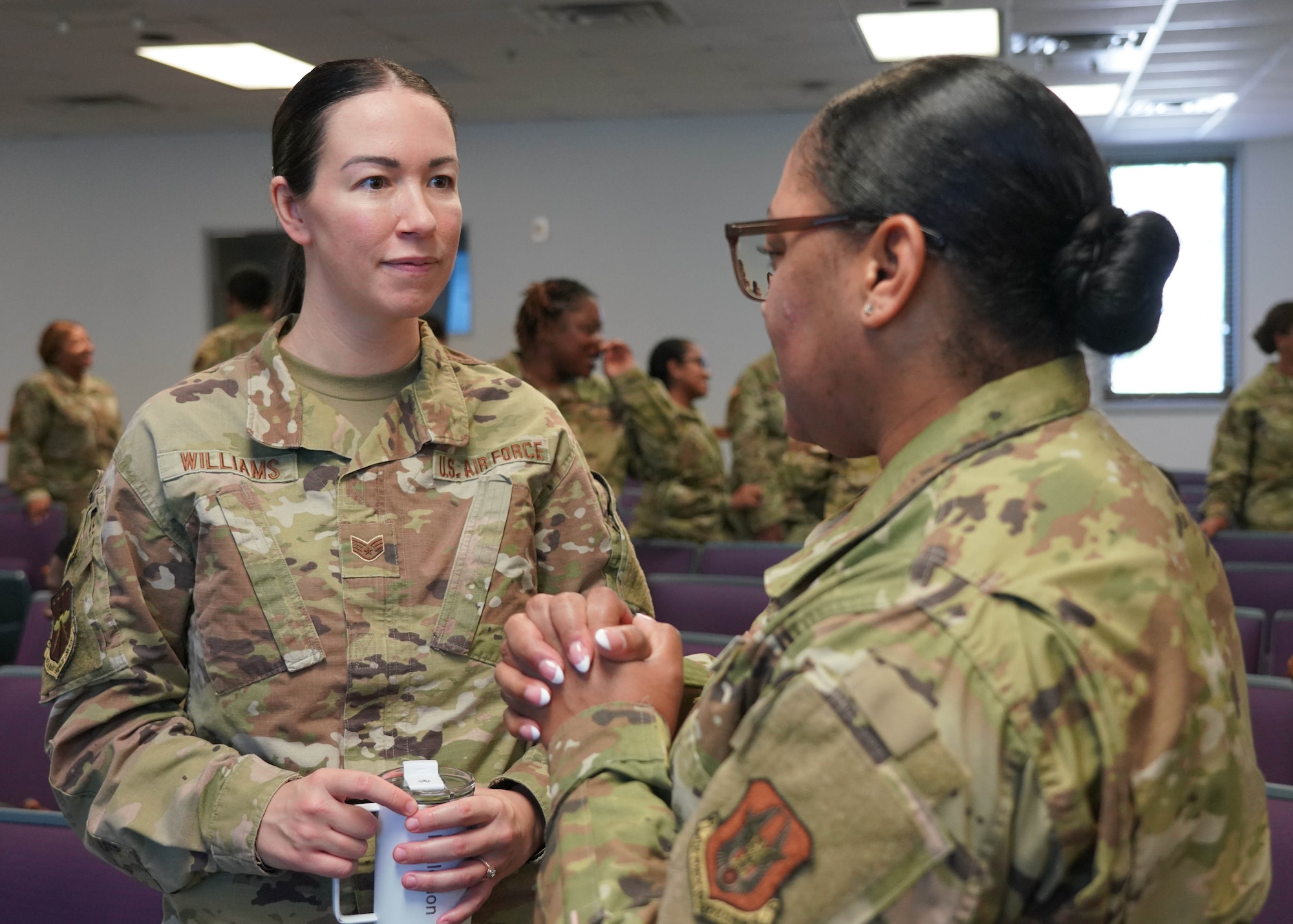 Airmen interacting with each other at a conference.