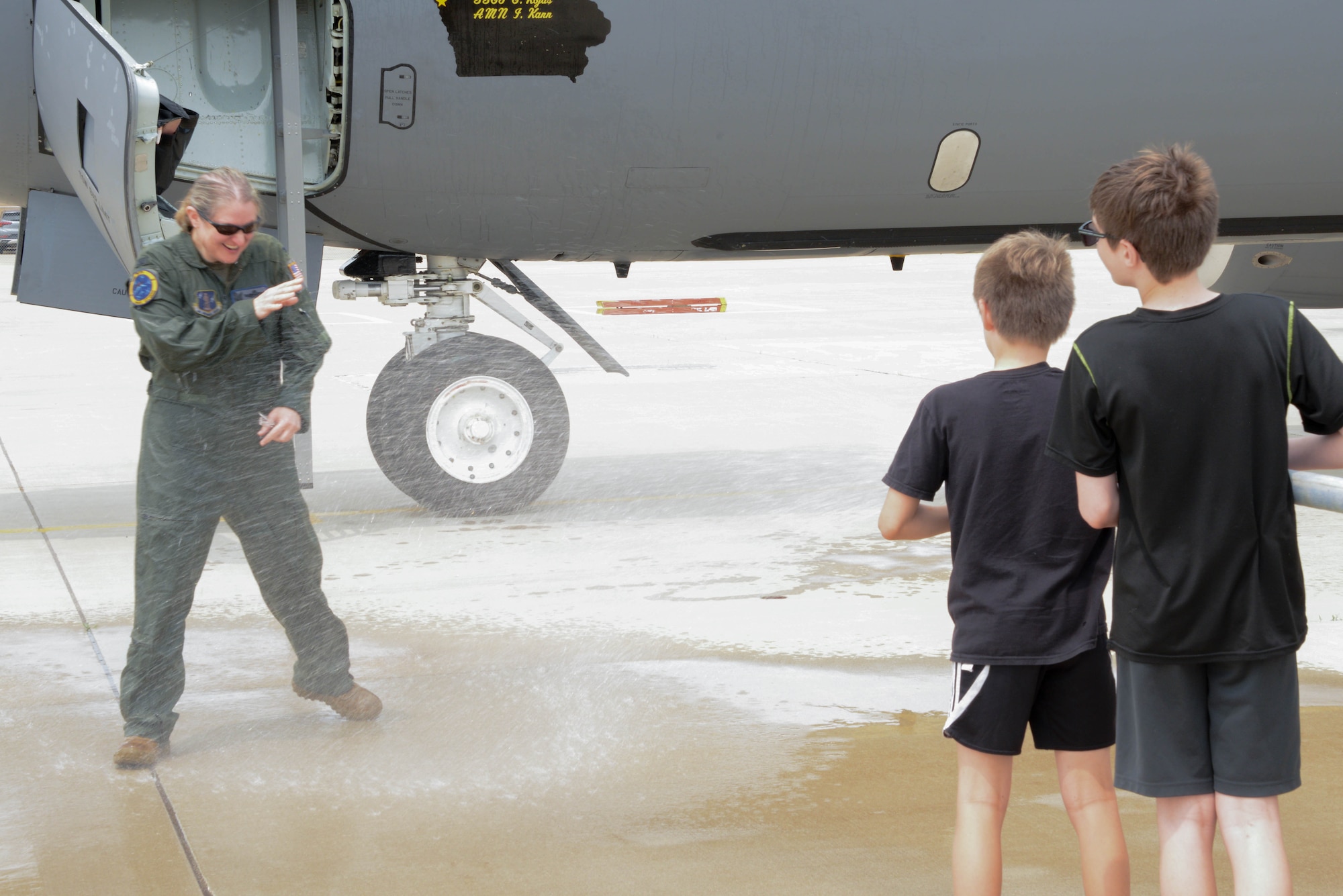 U.S. Air National Guard Col. Sonya Morrison, outgoing 185th Air Refueling Wing Commander, left, is sprayed with water by her children, right