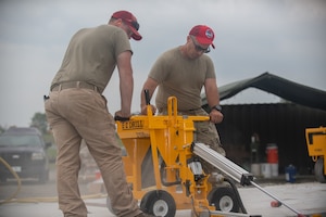 Tech Sgt. William Leinbach, assigned to the 201st RED HORSE, drills concrete at Fort Indiantown Gap, Pennsylvania, June 7, 2025.