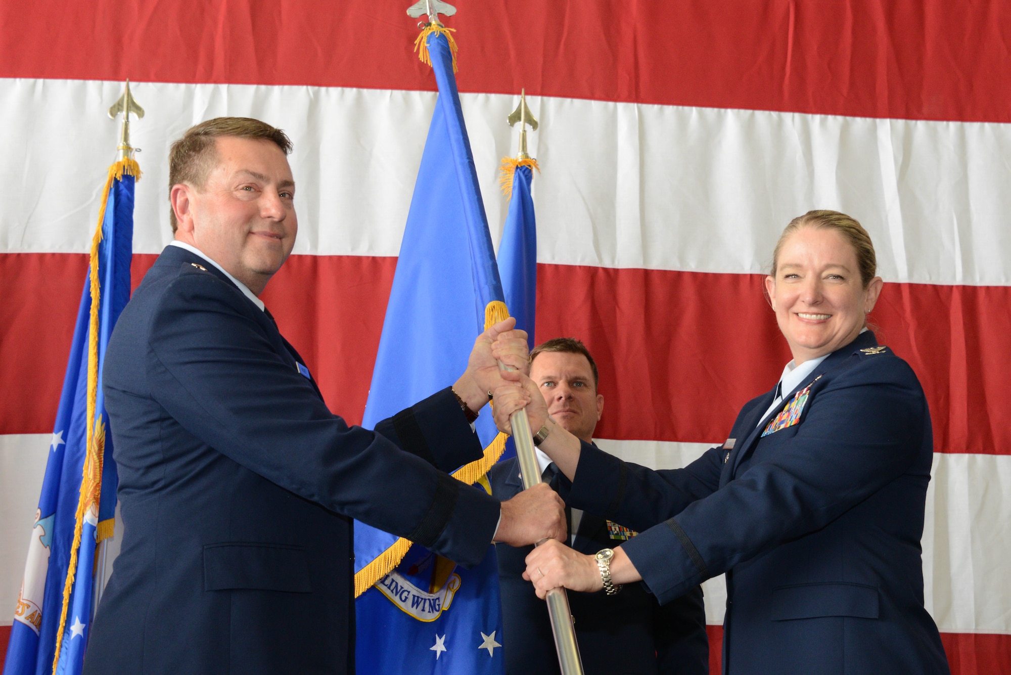 U.S. Air National Guard Col. Sonya Morrison, outgoing 185th Air Refueling Wing Commander, right, relinquishes command of the 185th ARW by passing the unit’s guidon to Brig. Gen. Mark Muckey, Deputy Adjutant General for the Iowa Air National Guard, left,