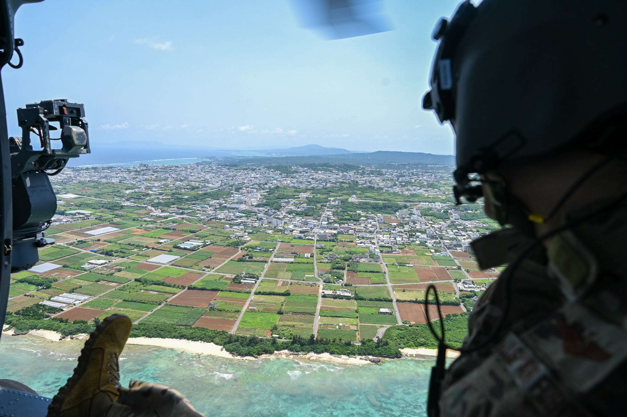 A U.S. Air Force HH-60W Jolly Green II flies over the coast of Okinawa.