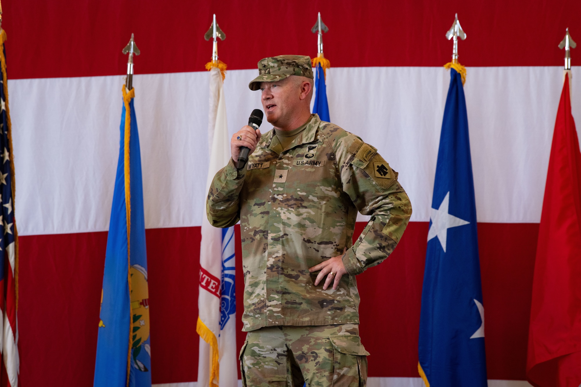 a man in uniform talks with a microphone in hand