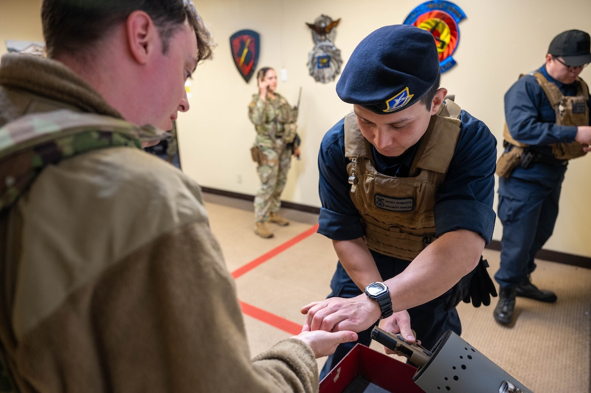 A U.S. Air Force Civilian Guardsmen (CG) assigned to the 35th Security Forces Squadron, clears and de-arms his service weapon at Misawa Air Base, Japan, June 5, 2025