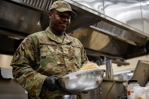 U.S. Air Force Staff Sgt. Kenneth Bradshaw, 35th Force Support Squadron food service shift leader, tosses spices for prime ribs in a bowl.