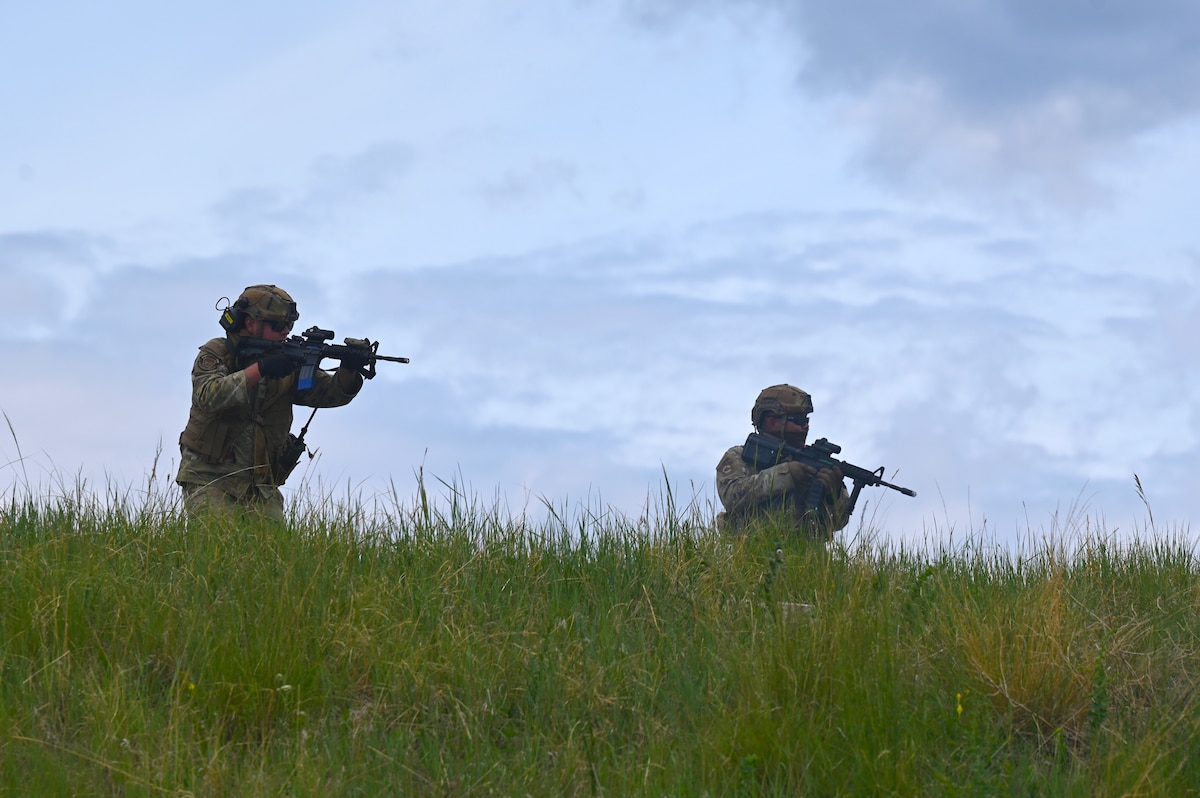 Defenders from the 161st, 162nd, and 171st Security Forces Squadrons raise their weapons during a patrol field training exercise