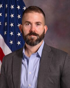 Clint Work is pictured in front of a U.S. flag for his official headshot at NDU.