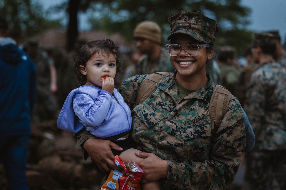 U.S. Marine Corps Staff Sgt. Frenesis Bernal, a New Jersey native and food service specialist with Combat Logistics Battalion 22, poses for a photo with her daughter after returning from Norway for Exercise Swift Reponse 25,Marine Corps Base Camp Lejeune, North Carolina, May 27, 2025. The Marine Corps provided direct combat service support to the U.S. Army 82nd Airborne Division to enable sustainment of multi-domain operations. Swift Response 25 is part of the DEFENDER 25 series and allows the rehearsal, deployment, employment, and integration of U.S. forces to focus on the expansion of critical capabilities on the battlefield in the High North and Baltics. (U.S. Marine Corps photo by Sgt. Jorge Borjas)