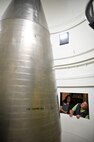 People look into a launch facility containing a test intercontinental ballistic missile.