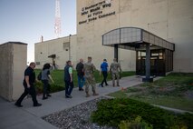 Airmen and civilians walk into a building