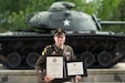 Army Maj. Christopher Bizor holds his Certificate of Retirement and Certificate of Appreciation during his retirement ceremony at Patton Hall, Shaw Air Force Base, S.C., May 8, 2025.
