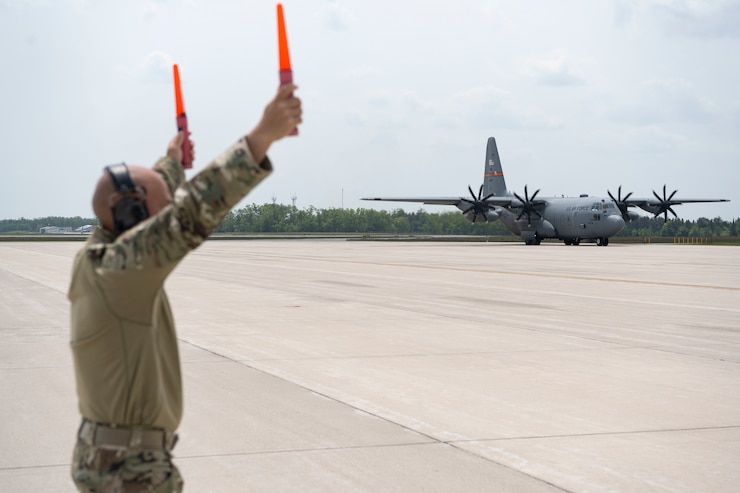 U.S. Air Force Master Sgt. Angel Jimenez, intel analyst craftsman, 156th Contingency Response Group, Puerto Rico Air National Guard, marshals a C-130H Hercules aircraft assigned to the 182nd Airlift Wing, during exercise Sentry North at Alpena Combat Readiness Training Center, Michigan, June 3, 2025. Sentry North 2025 focused on operating in a contested environment with adversary aircraft, electronic jamming, and simulated surface-to-air threats, providing a premier joint training opportunity to ensure participating units are combat-ready and interoperable in operationally limited environments. (U.S. Air National Guard photo by Master Sgt. Rafael D. Rosa)
