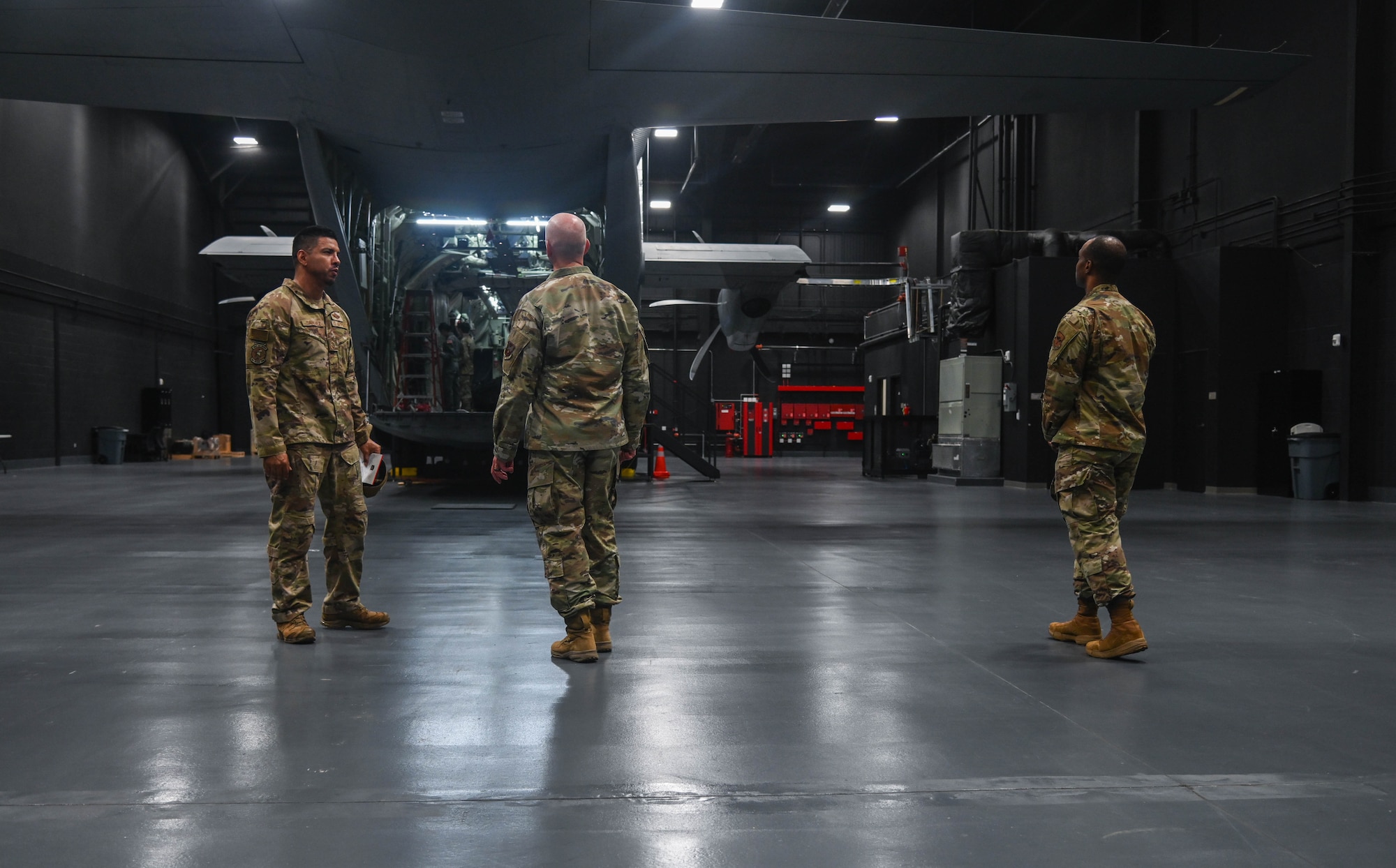 Service members look at the back of an aircraft.