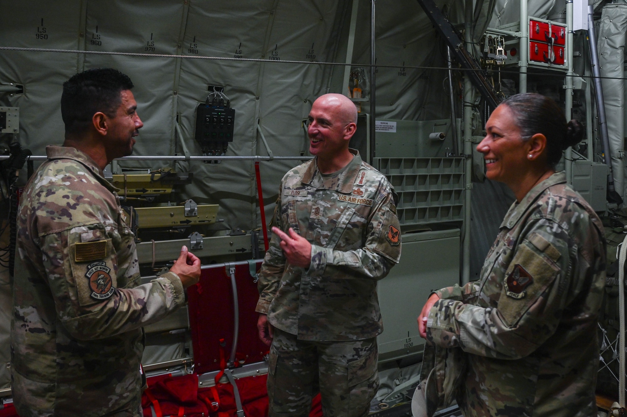 Service members talk in the back of an aircraft.
