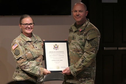 Lt. Col. Allison Jacobs, commander of the 634th Brigade Support Battalion, presents Master Sgt. Francis Sarnecki with a certificate of retirement.