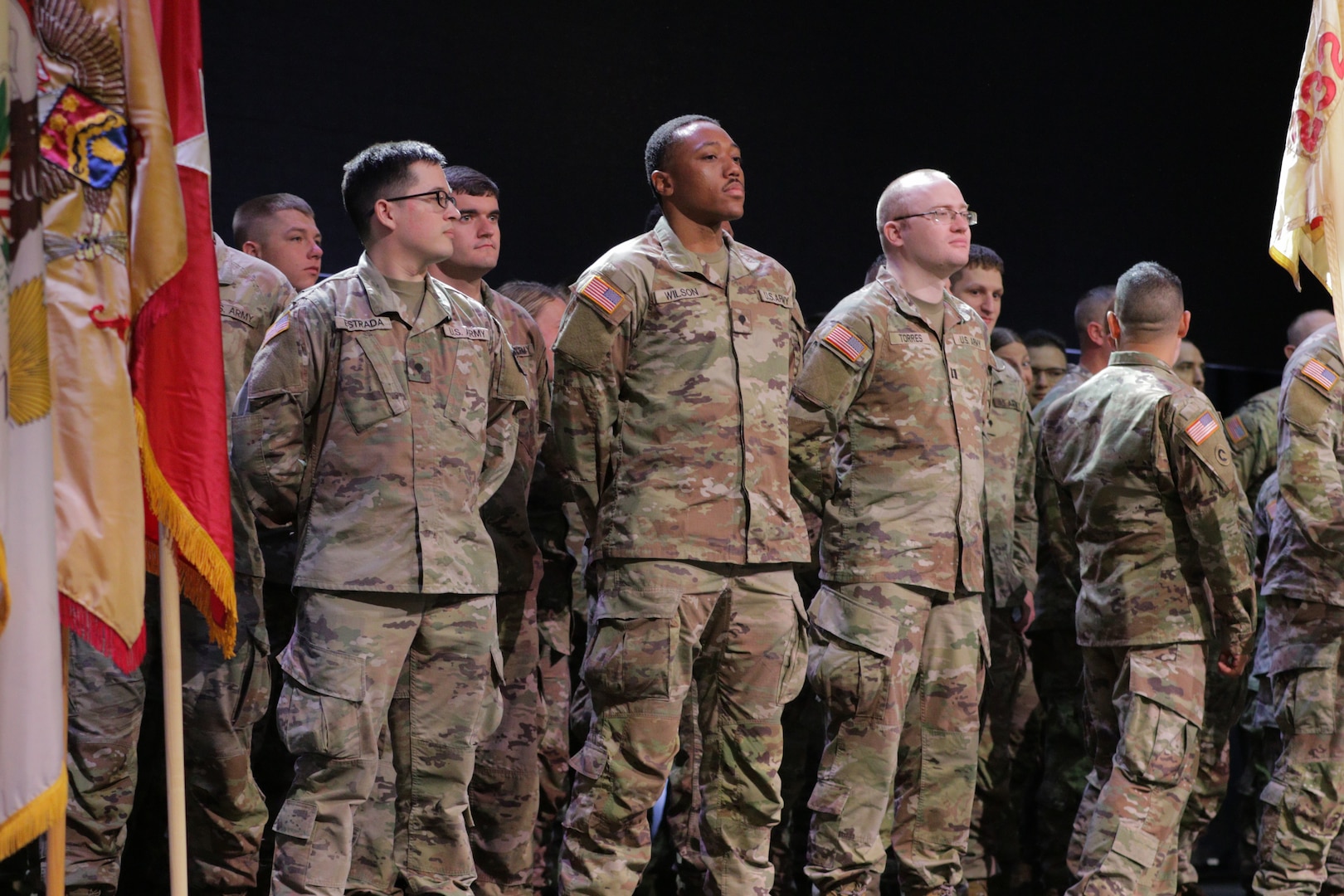 Spc. Quentin Estrada, Spc. Kameron Wilson, and Capt. Justin Torres of the Illinois Army National Guard’s 232nd Combat Sustainment Support Battalion stand in formation during their mobilization ceremony