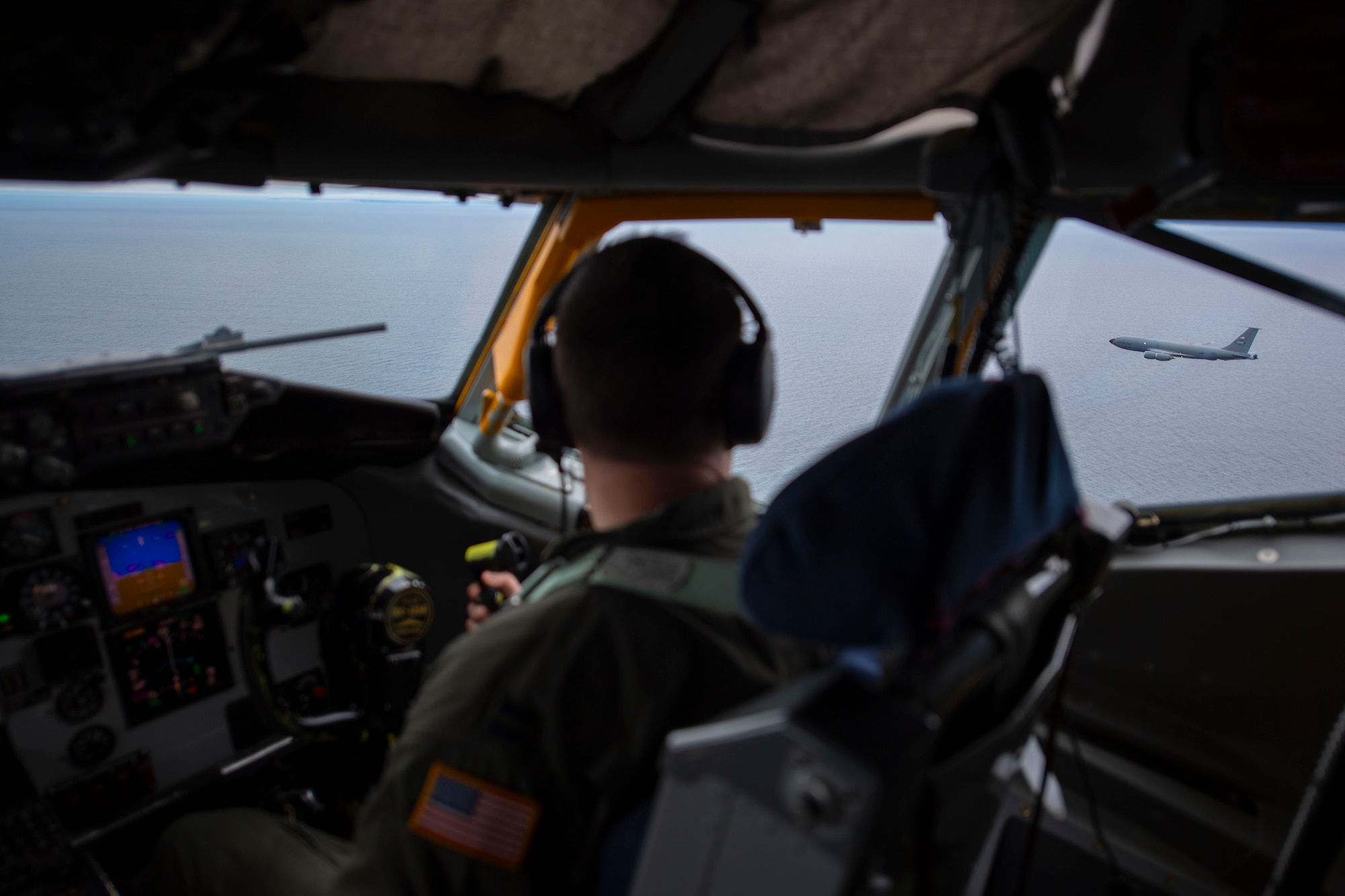 View from the flight deck of KC-135 and a pilot looking at another aircraft flying in distance