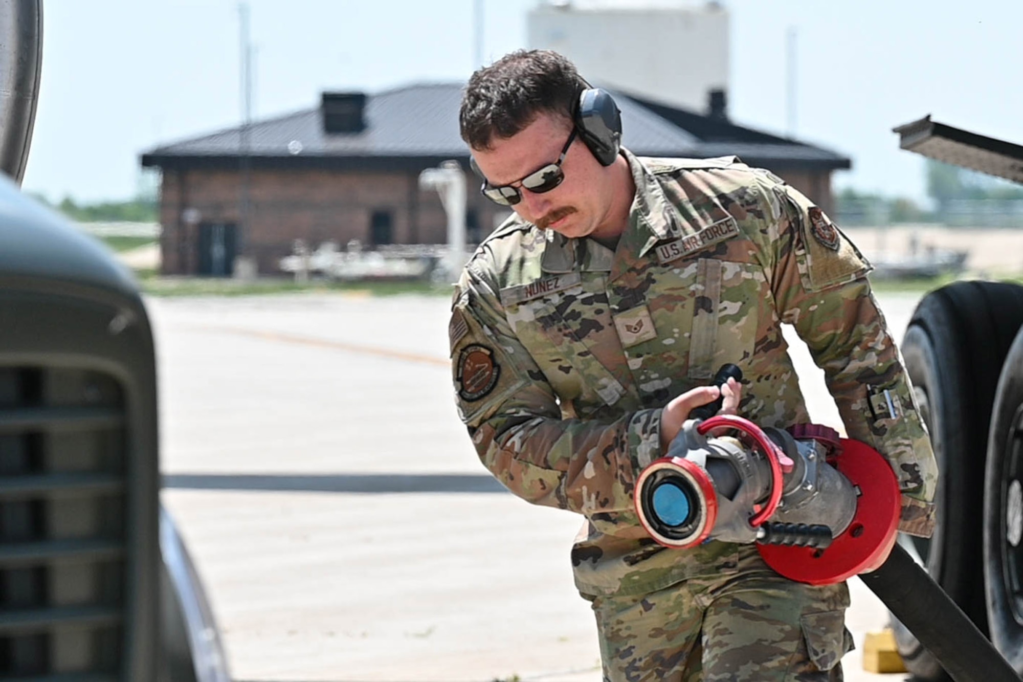 Airman pulls gas hose back to truck