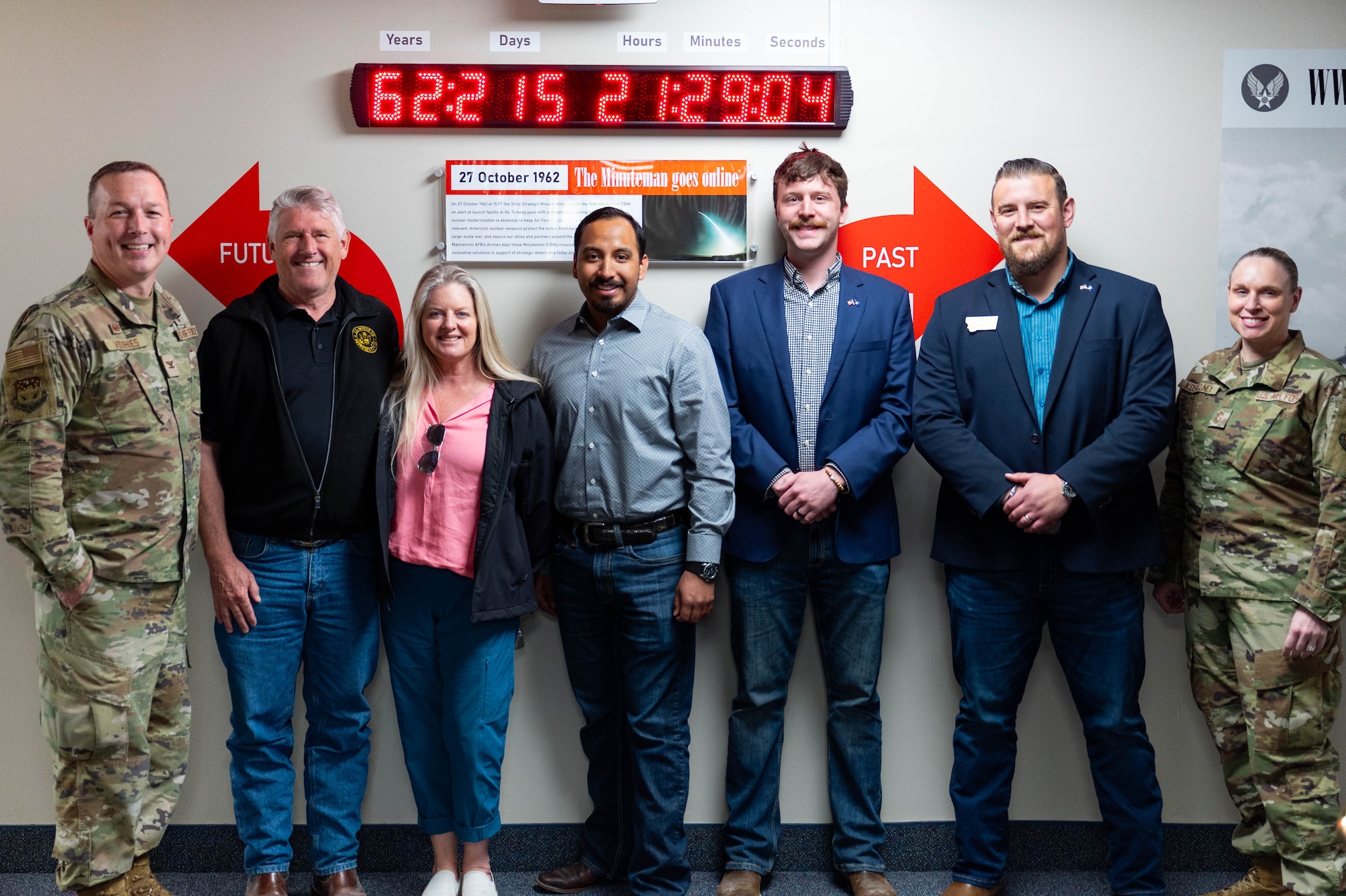 People posing in front of a digital clock