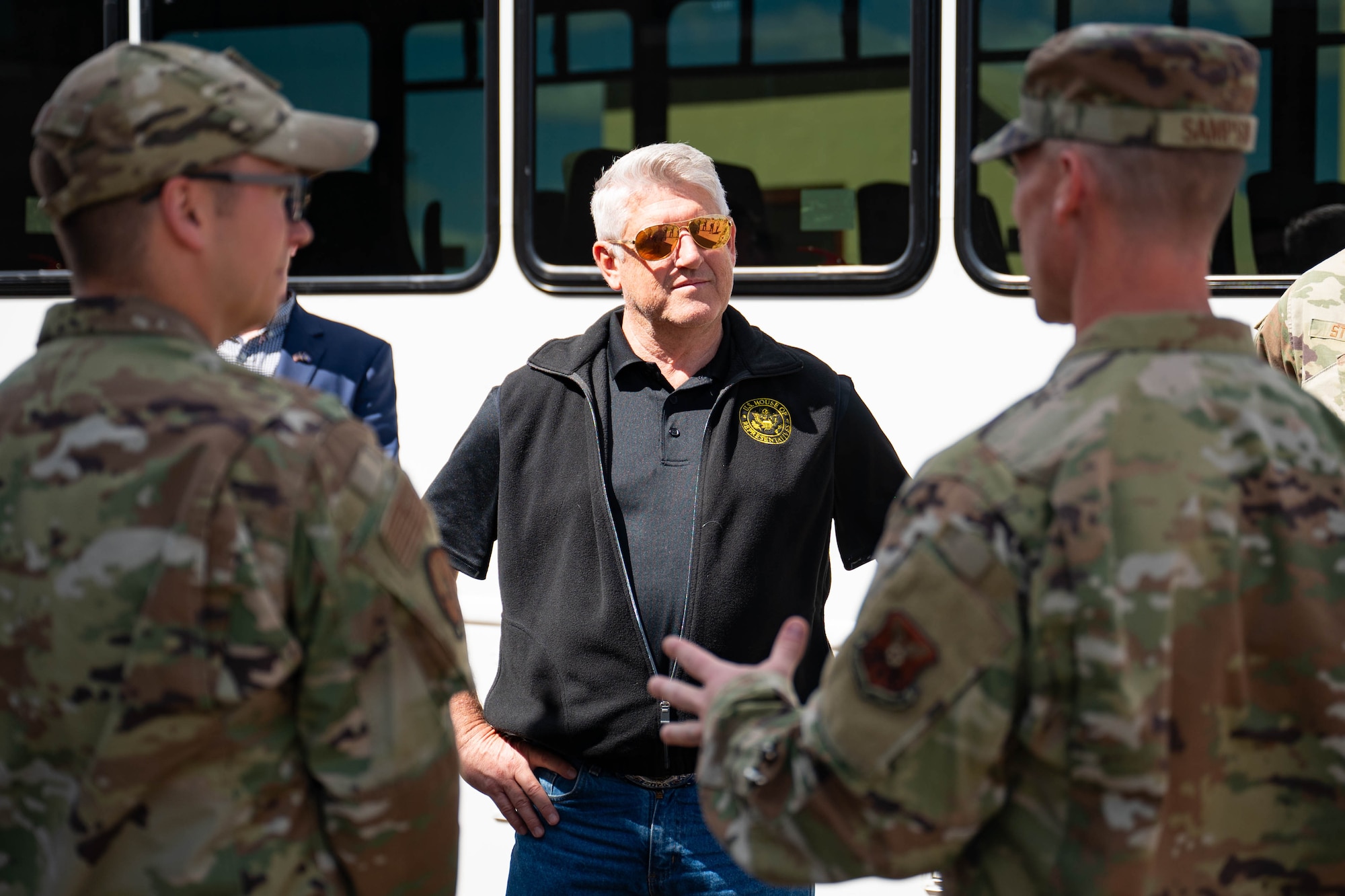 Man looking towards two Airmen conversing in his direction