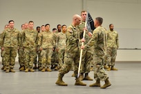 Captain Caleb D. Rogers, commander of the 111th Electromagnetic Warfare Company receives the recently uncased unit guidon from Lt. Col.  Luke E. Gurley, commander of the 221st Intelligence and Electronic Warfare Battalion, assuming his new role as commander, June 7, 2025 in Forest Park, Ga.