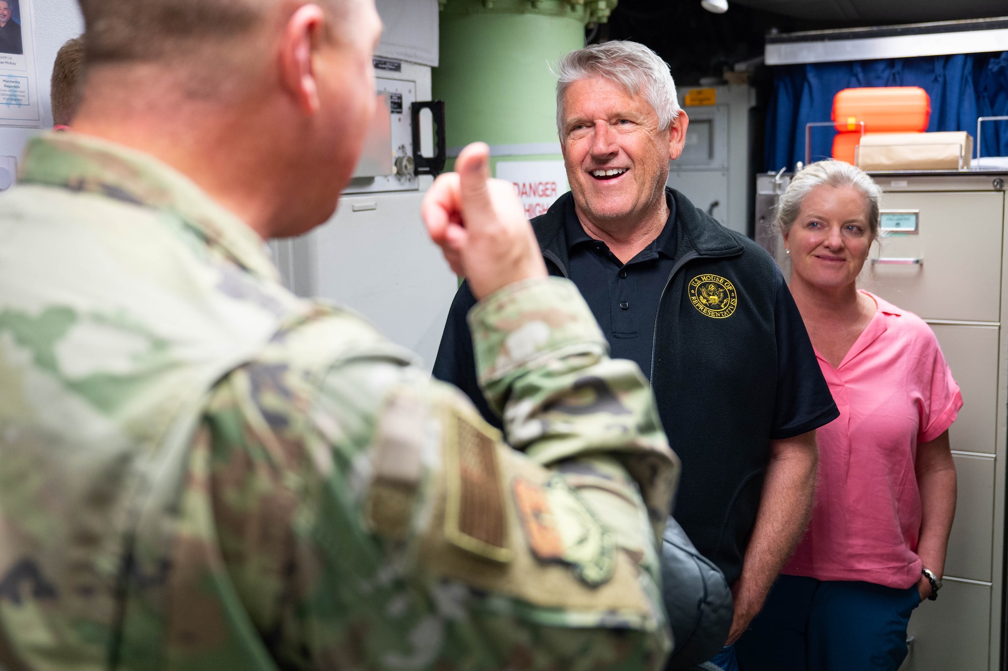 two civilians looking towards an Airman