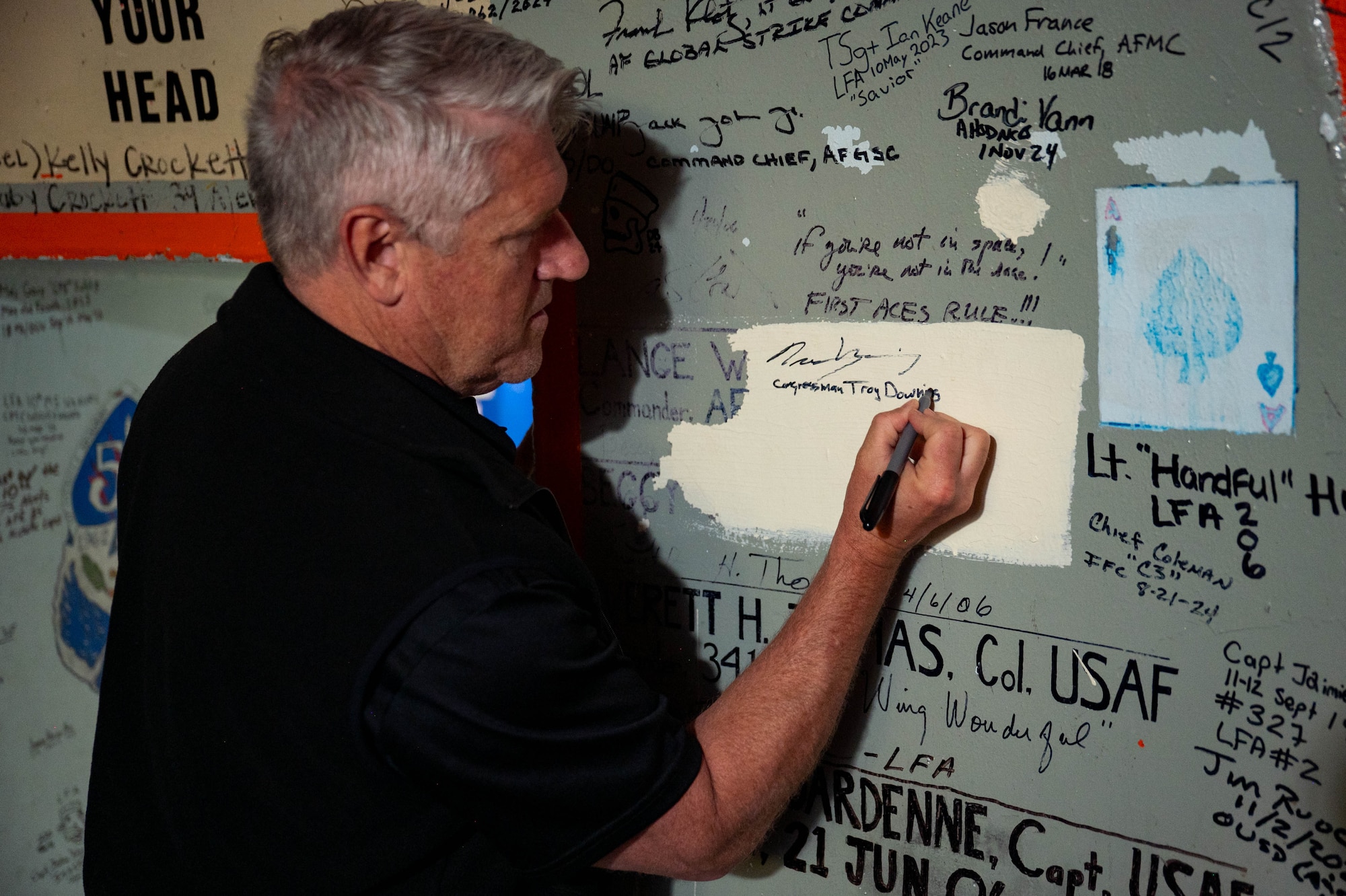 Man signs name onto wall
