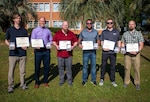 Members from the NSWC PCD Standoff Target Reacquire Identify Detection Expeditionary Navigation Tool (STRIDENT) Program receive the Navy Civilian Service Achievement Medal for enhancing warfighter capabilities, April 18, 2025. (from left) David Trexler, Dr. John Kelly, Steven Roberts, Aaron Burghardt, Joshua Lowe, Jonathan Outlaw, and Christine Livingston (not pictured). (U.S. Navy photo by Anthony Powers)