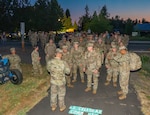 Participants gather at the start line in the pre-dawn light at U.S. Cellular Field in Medford, Ore., June 8, 2025, before beginning the Norwegian Foot March.
