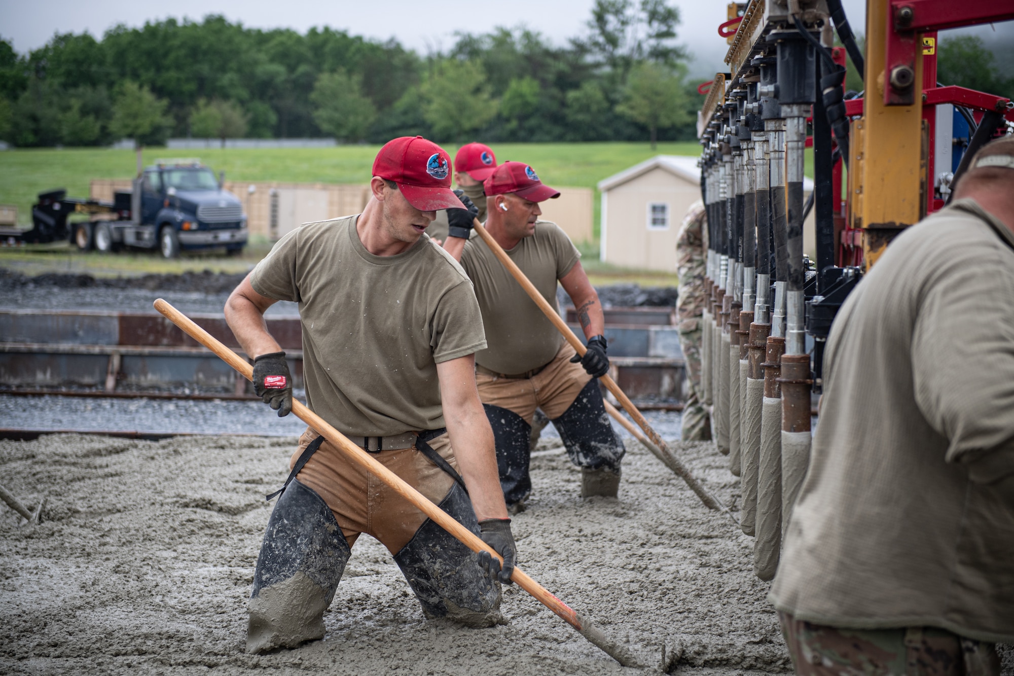 Airmen from various civil engineering specialties spread out concrete as they construct a Rapid Airfield Damage Repair system at Fort Indiantown Gap, Pennsylvania.