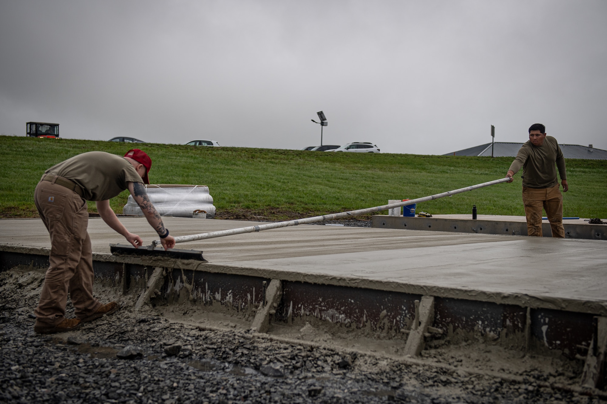 Staff Sgt. Kyson Edwards, left, a heavy equipment operator with the 201st RED HORSE Squadron and Staff Sgt. Emilio Ocampo, a pavements and construction specialist with the 820th RED HORSE Squadron, finishes a concrete surface during the construction of a Rapid Airfield Damage Repair system at Fort Indiantown Gap, Pennsylvania