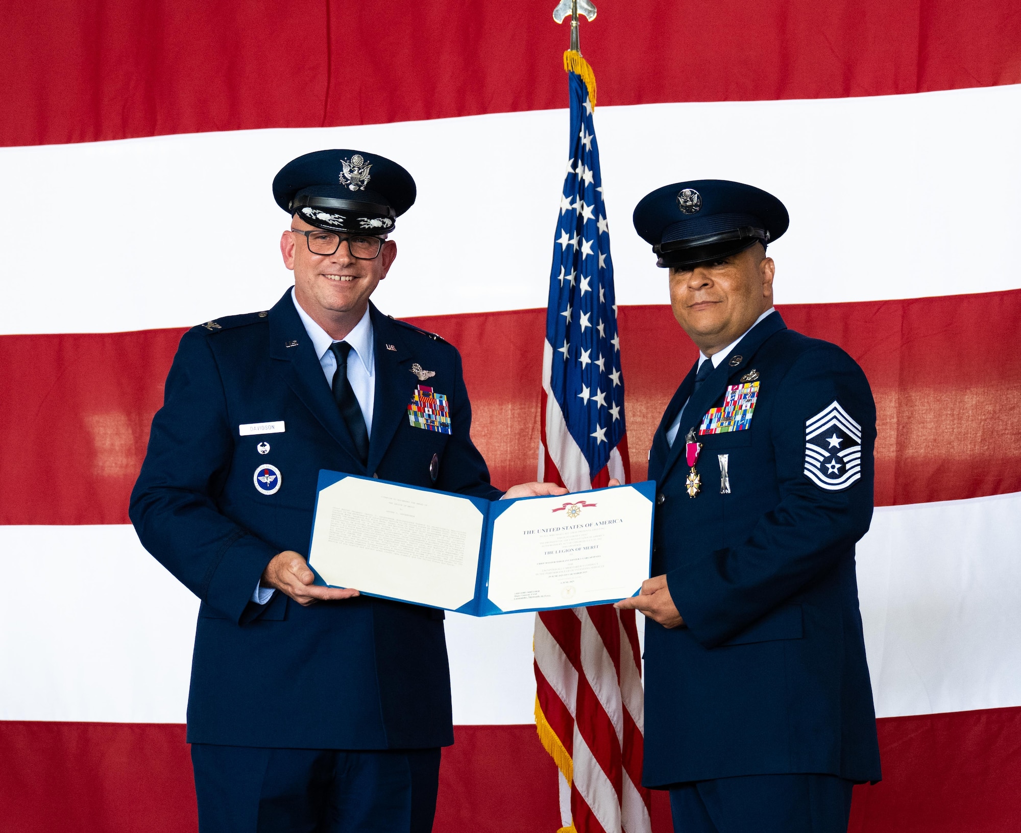 U.S. Air Force Col. Kevin Davidson, left, Africa Command Washington Liaison Office, director, presents the Legion of Merit to Chief Master Sgt. Lester Largaespada, right, 47th Flying Training Wing command chief, at Laughlin Air Force Base, Texas, June 6, 2025. The retirement ceremony celebrated the 29 year career of Largaespada. (U.S. Air Force photo by Staff Sgt. Nicholas Larsen)