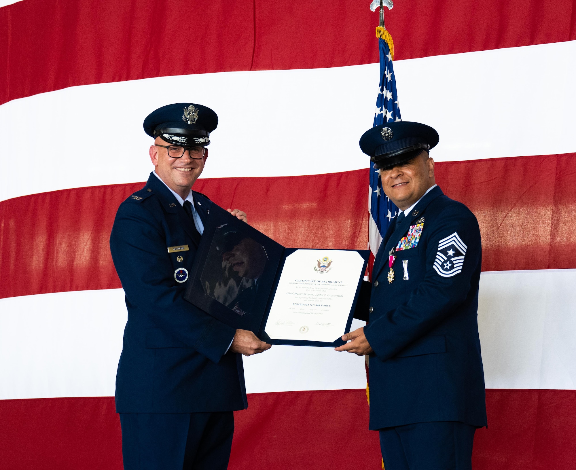 U.S. Air Force Col. Kevin Davidson, left, Africa Command Washington Liaison Office, director, presents the Certificate of Retirement to Chief Master Sgt. Lester Largaespada, right, 47th Flying Training Wing command chief, at Laughlin Air Force Base, Texas, June 6, 2025. The retirement ceremony celebrated the 29 year career of Largaespada. (U.S. Air Force photo by Staff Sgt. Nicholas Larsen)