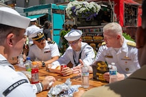 PORTLAND, OREGON (June 7, 2025) – U.S. Navy Vice Adm. John Wade, commander, U.S. 3rd Fleet, right, speaks with Sailors and Marines while having lunch at Midtown Beer Garden during Portland Fleet Week, June 7, 2025. Portland Fleet Week is a time-honored celebration of the sea services and provides an opportunity for the citizens of Oregon to meet Sailors, Marines and Coast Guardsmen, as well as witness firsthand the latest capabilities of today’s maritime services. (U.S. Navy Photo by Mass Communication Specialist 2nd Class John A. Miller)