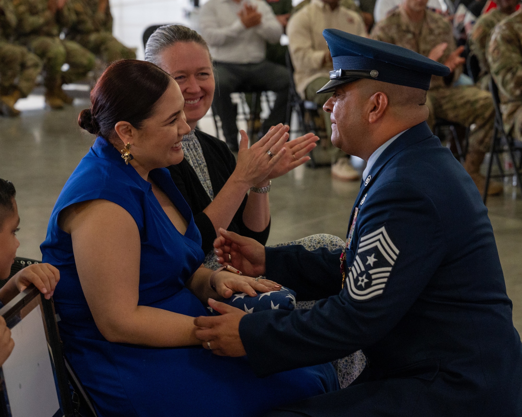 Esmerelda Largaespada, left, is given a flag by Chief Master Sgt. Lester Largaespada, right, 47th Flying Training Wing command chief, at Laughlin Air Force Base, Texas, June 6, 2025. The retirement ceremony celebrated the 29 year career of Largaespada. (U.S. Air Force photo by Staff Sgt. Nicholas Larsen)