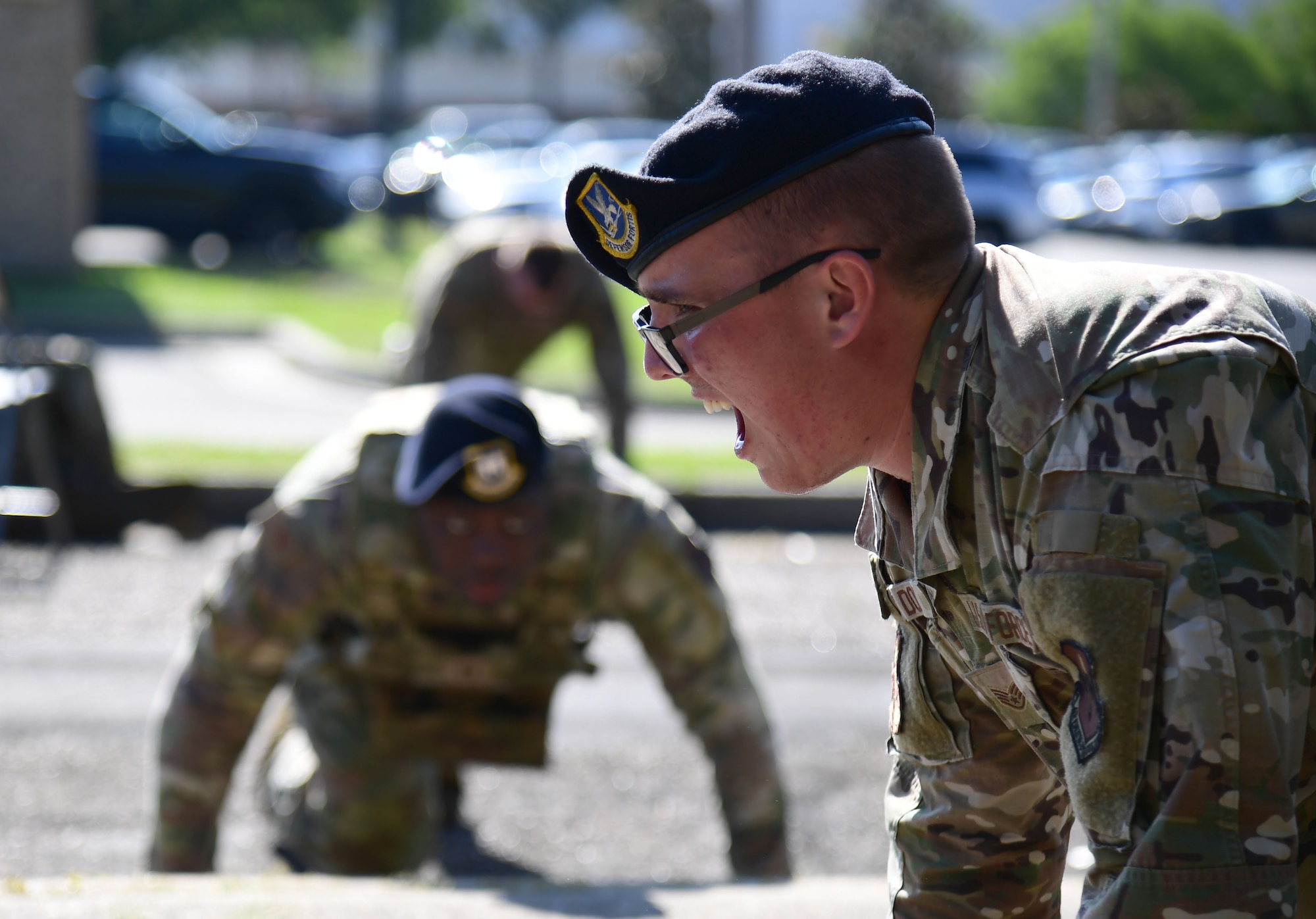 Military personnel do push-ups outside