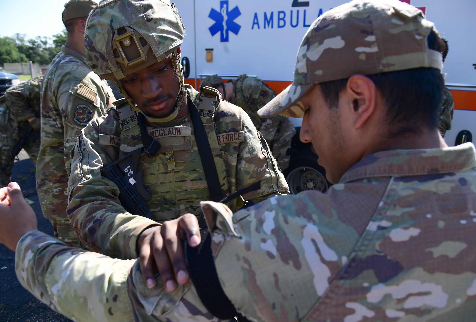 A Security Forces Squadron defender, applies a tourniquet on the arm of an Airman