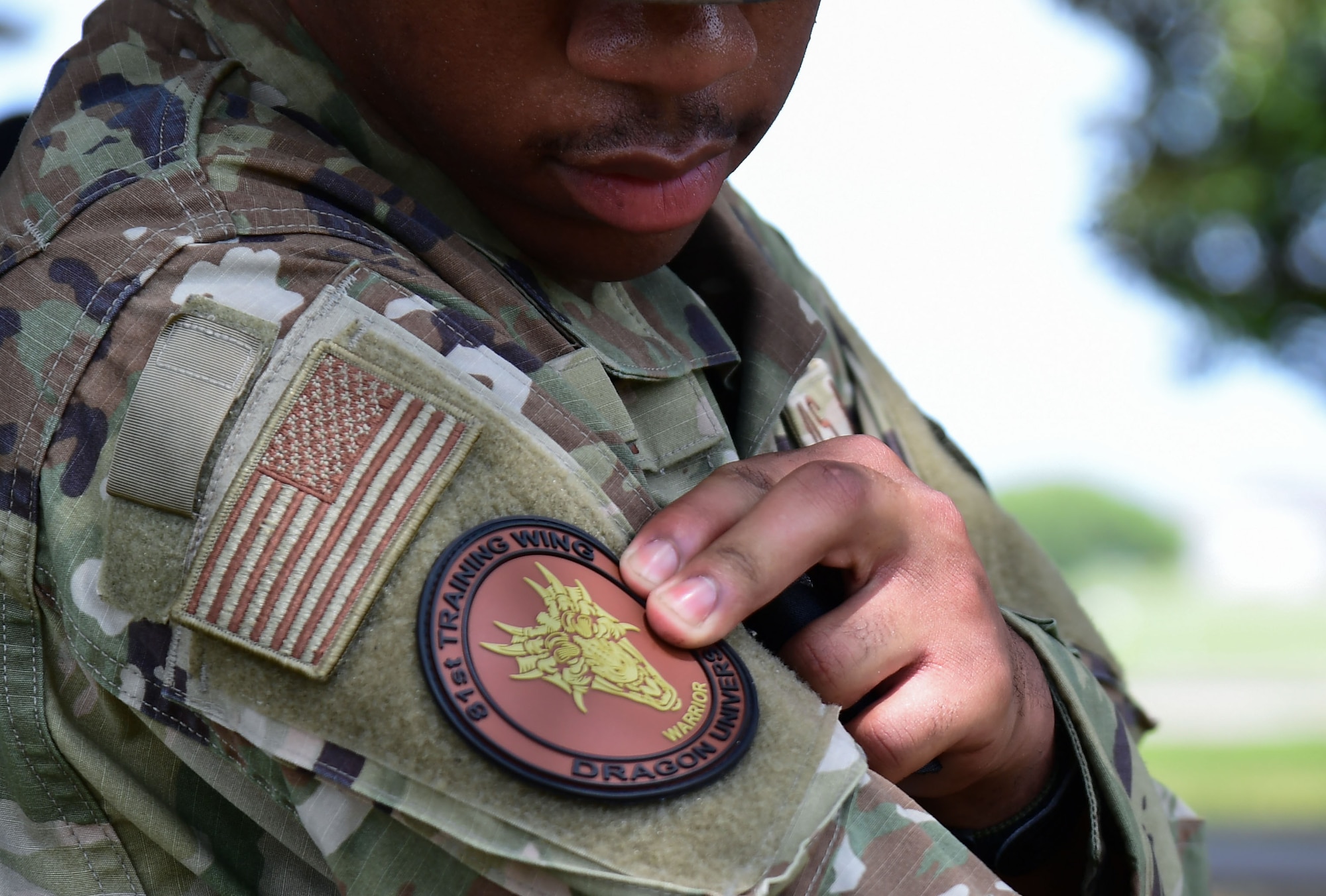 81st Logistics Readiness Squadron vehicle maintenance technician, secures a patch to his uniform after completing Warrior Day