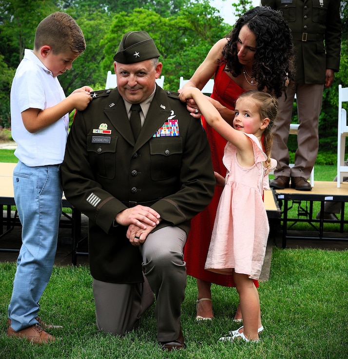 Illinois Army National Guard Maj. Gen. Justin Osberg watches as his son, 7-year-old Evan, and daughter, 4-year-old Juliana, pin his second star on his uniform with help from his spouse, Jessica