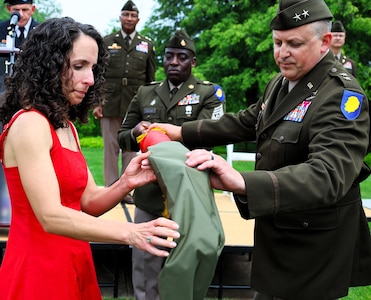 Illinois Army National Guard Maj. Gen. Justin Osberg and his spouse, Jessica, uncase his Two-Star General Officer Flag during Osberg’s promotion ceremony