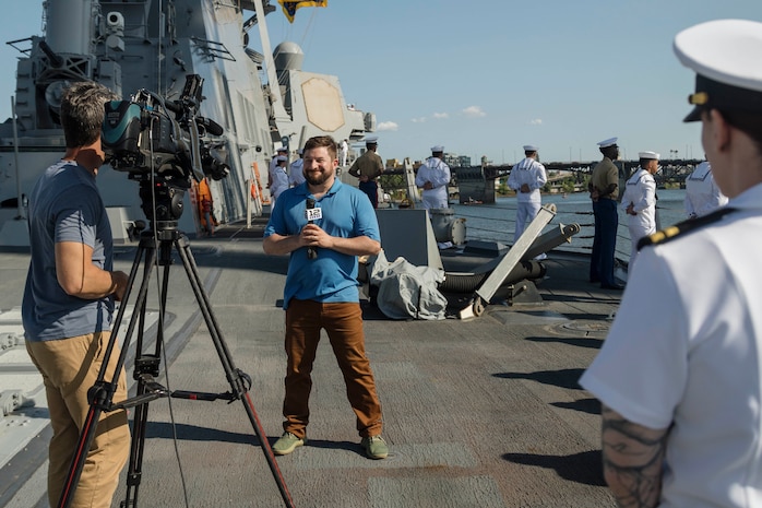 PORTLAND, OREGON (June 3, 2025) – Fox 12 Oregon’s Ezra Kaplan airs a live report aboard the Arleigh Burke-class guided missile destroyer USS Mustin (DDG 89) sailing in the Willamette River as it arrives for Portland Fleet Week during the 118th Rose Festival, June 3, 2025. Portland Fleet Week is a time-honored celebration of the sea services and provides an opportunity for the citizens of Oregon to meet Sailors, Marines, and Coast Guardsmen, as well as witness firsthand the latest capabilities of today’s maritime services. (U.S. Marine Corps photo by Sgt. Amelia Kang)